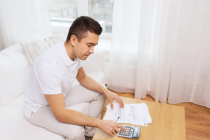 Man looking over documents and making calculations